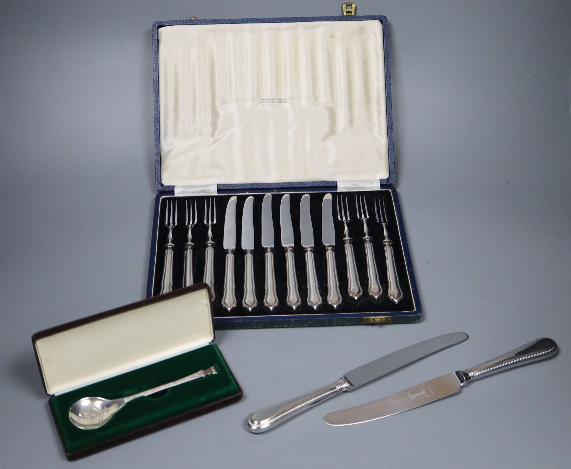 A cased set of 6 pairs of silver handled dessert knives & forks, a Peter Jackson Christmas spoon and a set of plated table knives